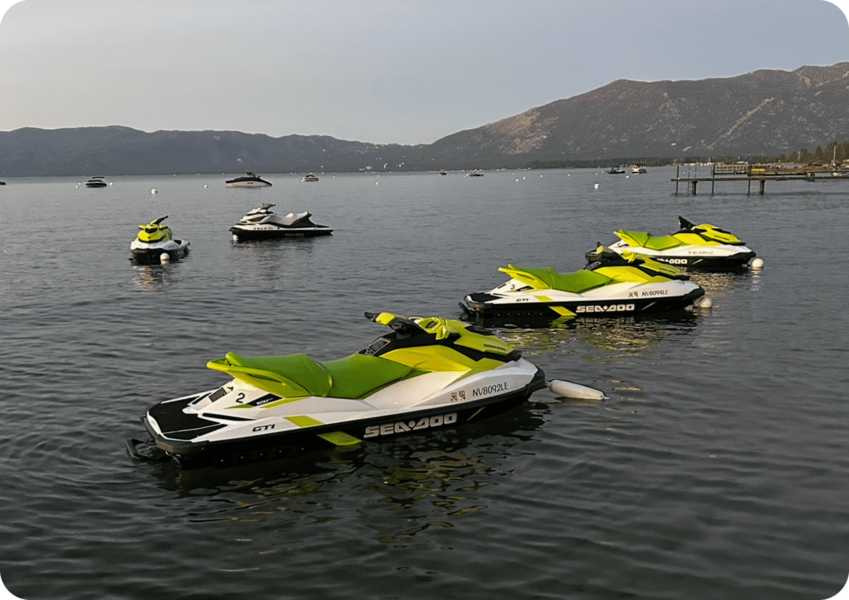 Jet skis floating on a calm lake.